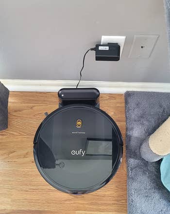 a reviewer photo of the vacuum on it's plugged-in charging dock 