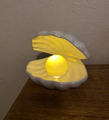 A decorative pearl nightlight in a clamshell design showcased on furniture