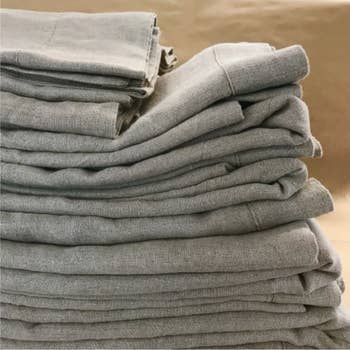 A pile of folded light grey linen