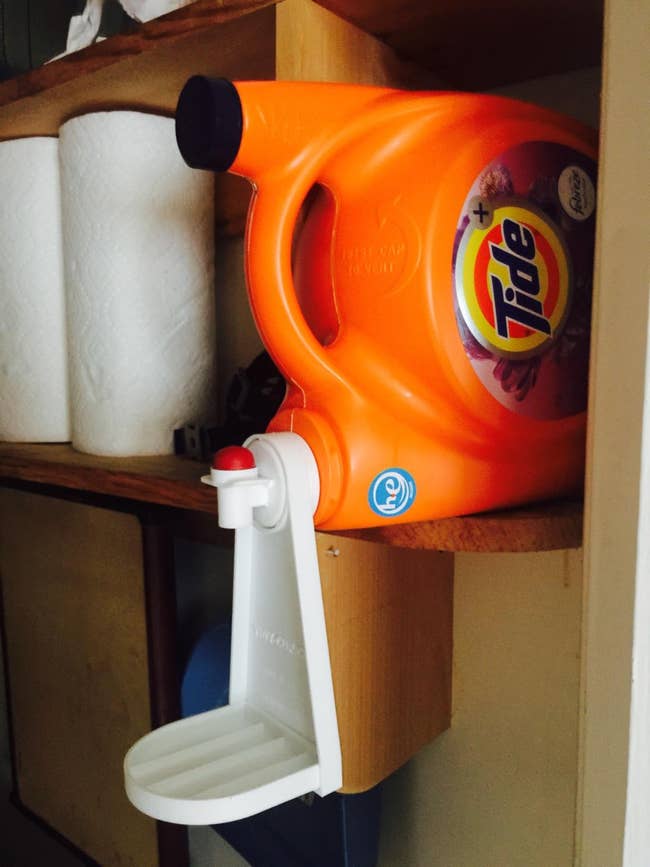 the white caddy attached to the mouth of a tide detergent bottle