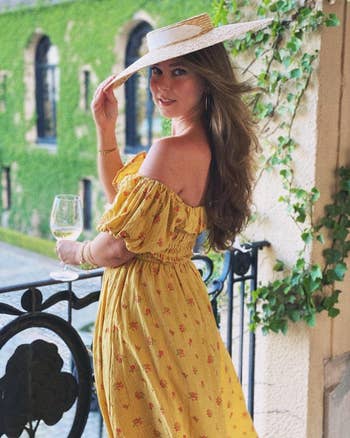 another reviewer wearing the yellow dress styled with sleeves off the shoulder