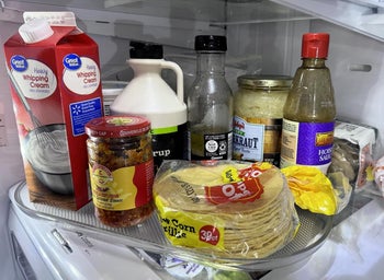 Assorted condiments and dairy products on a reviewer's lazy Susan on a refrigerator shelf