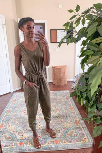 a reviewer wearing the jumpsuit in green