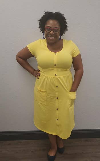 reviewer in the button front short sleeve dress in yellow with a hand in one of the pockets