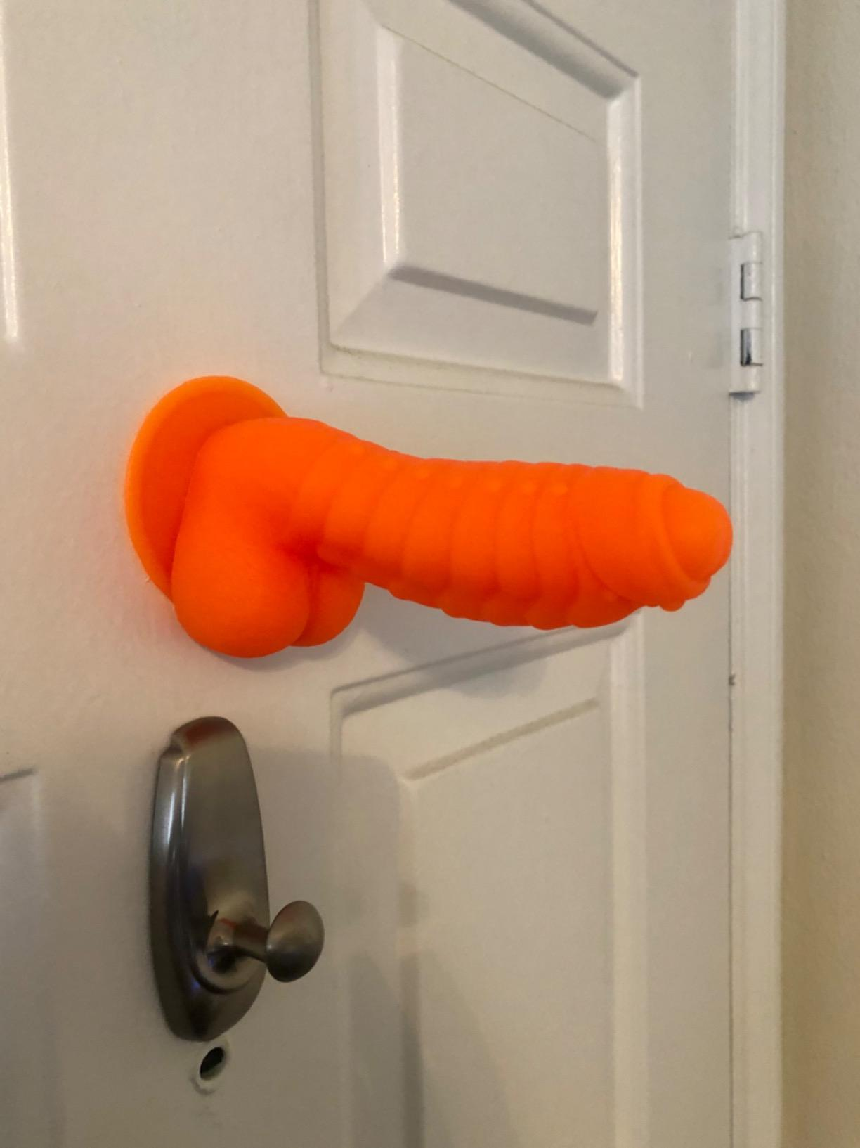 Orange dildo attached to door