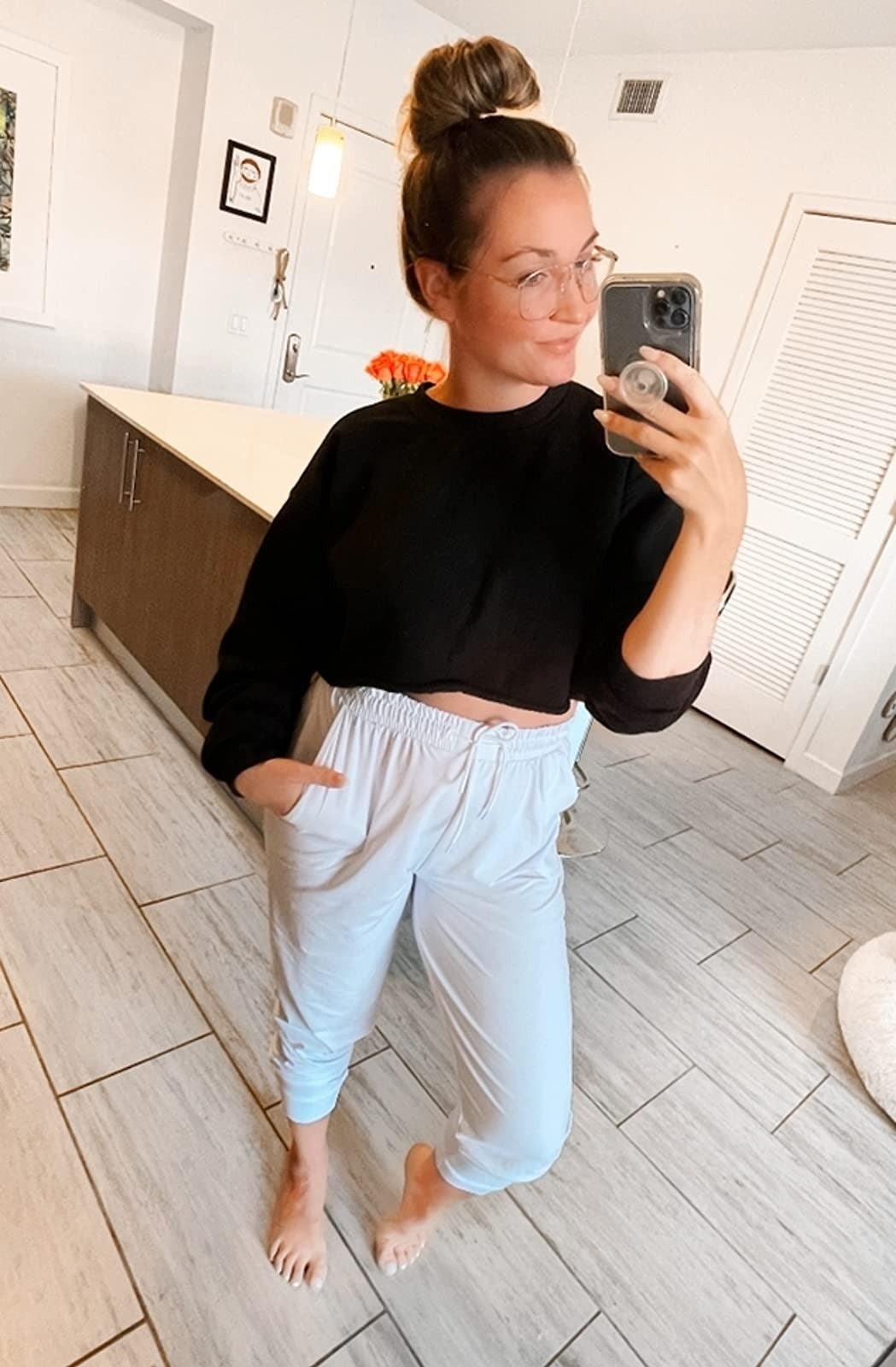 reviewer wearing white joggers with cropped black sweatshirt