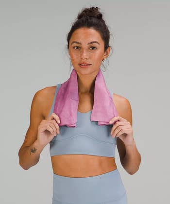 model with a small pink towel around their neck 