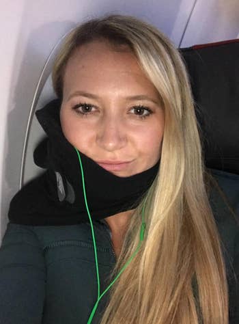 reviewer taking a selfie while wearing the neck pillow