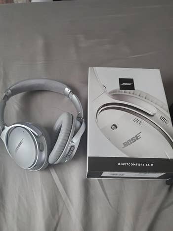 reviewers silver Bose headphones next to the box