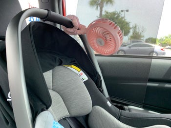 reviewer's photo of the stroller fan attached to a car seat