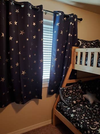 Reviewer's photo showing the navy blackout curtains in a child's bedroom