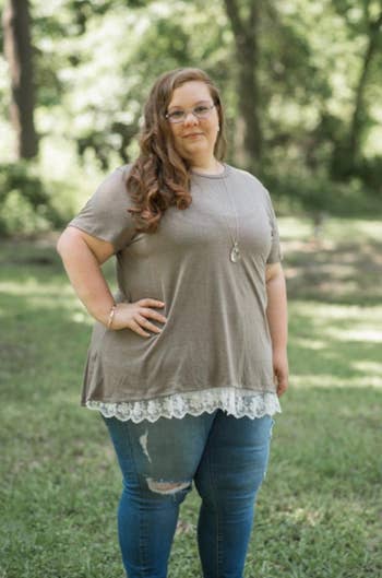 reviewer in a casual t-shirt with lace detailing, paired with jeans, standing outdoors