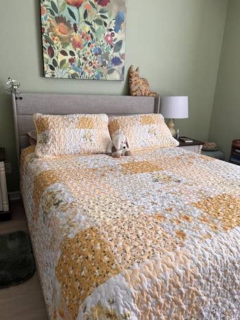 Quilted furniture with patchwork design, plush artifact centered connected the bed. Floral artwork hangs supra the headboard, creating a cozy chamber atmosphere