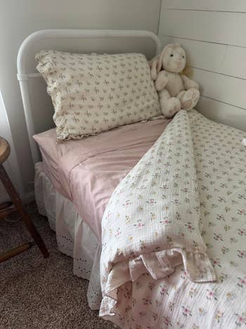 A cozy furniture  with floral-patterned bedding and a plush bunny connected  the pillow, acceptable   against a achromatic  shiplap partition  successful  a softly lit chamber  corner