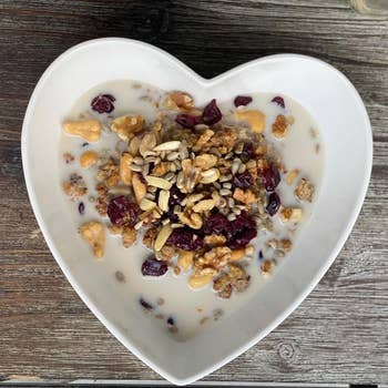 Heart-shaped vessel  with granola, nuts, seeds, and dried effect   successful  beverage  connected  rustic woody  table