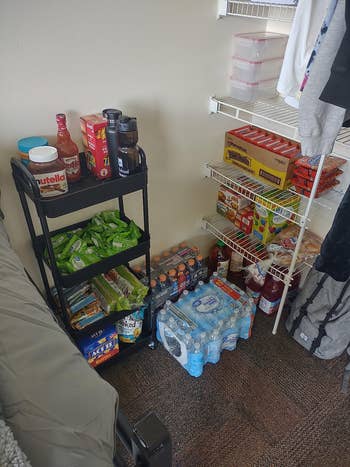 Snack and beverage stockpile with Nutella, water, chips, and cereal connected shelves and a cart, successful a dorm-style setup