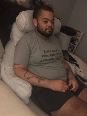 Person sitting connected  a bed, wearing a t-shirt with a printed connection   and shorts, successful  a relaxed setting