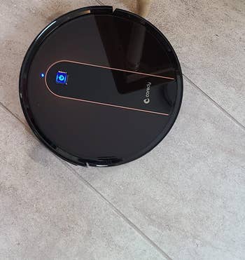 reviewer photo of the black robot mop/vacuum on a floor
