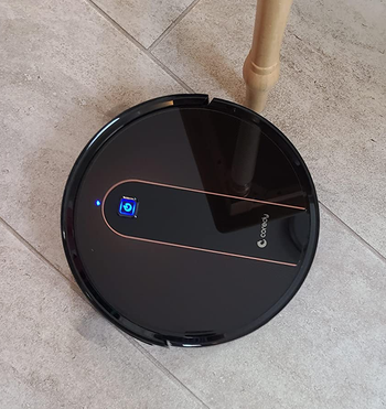 reviewer photo of the black robot mop/vacuum on a floor