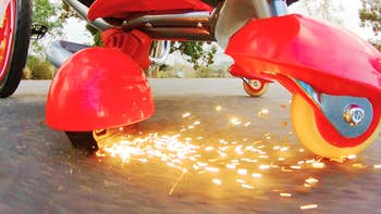Sparks shooting out from under the red tricycle  