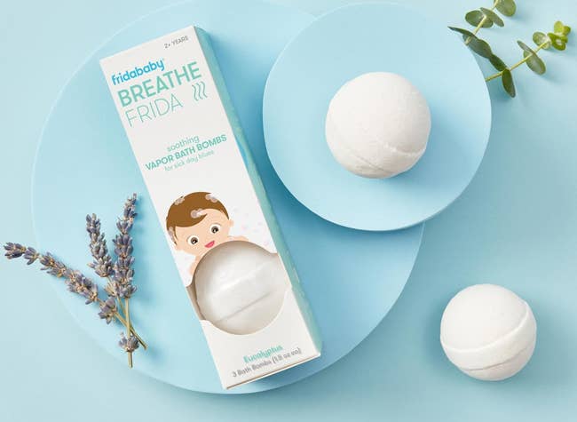 FridaBaby Breathe Frida soothing vapor bath bombs with eucalyptus and lavender, shown with packaging and a sprig of lavender