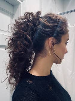 reviewer's high curly pony held up using the banana clip