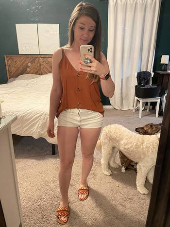 reviewer wearing the rust color version half tucked into shorts