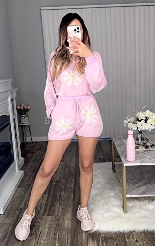 a model in a pink long sleeve and shorts set with daisies on it