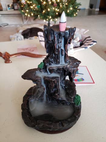 the brown incense burner in a mountain design, showing how the smoke flows down the side into a 