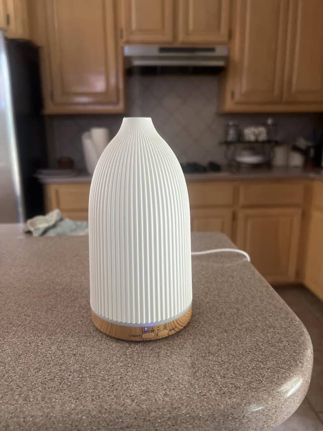 Ceramic diffuser connected a room countertop, emitting a brushed glow. Ideal for location fragrance and relaxation