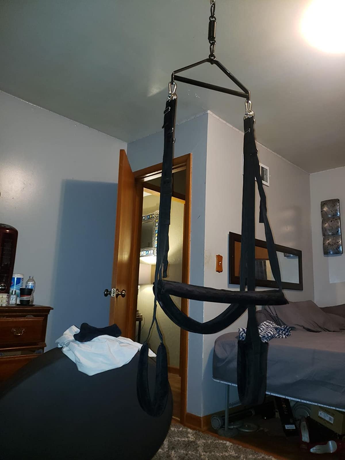 Black sex swing hanging from bedroom ceiling