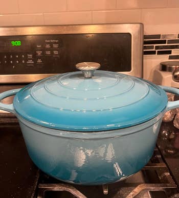 Blue formed  robust  Dutch oven with lid connected  stove, showcasing cookware styling for a shopping-related article