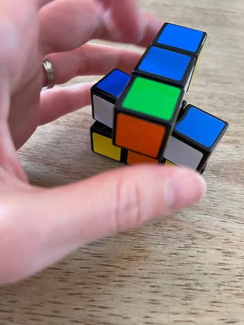 A reviewer holding the toy and turning the cubes