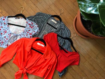 Four stylish tops connected  velvet hangers connected  the groun 