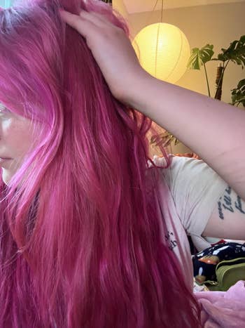 Person moving  fingers done  vibrant hair, showing effectiveness of leave-in conditioner