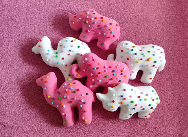 six pillows shaped similar  camels, elephants, and rhinos successful  the pinkish  and achromatic  styles