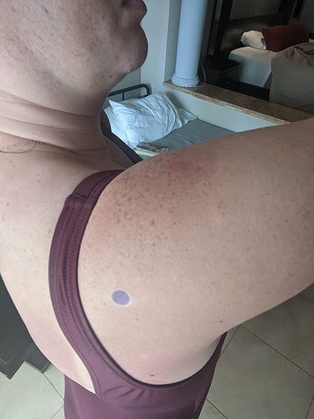 reviewer with one of the dot stickers on their shoulder and the sticker is purple