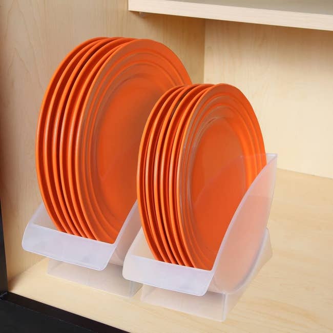 both of the holders in a cabinet holding orange salad and dinner plates