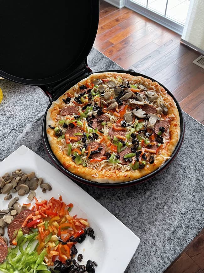 open pizza maker with a pizza on it