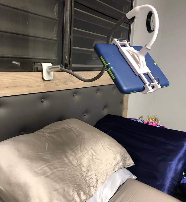Tablet holder mounted on reviewer's bed frame above the pillows
