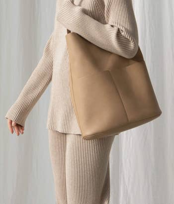 a model holding the beige purse