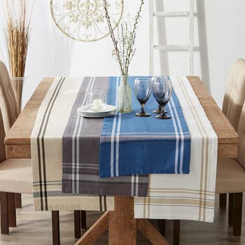 wood dining table with burlap stripe runners in different colors on it
