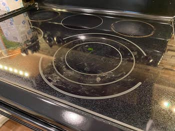 reviewer before image of a dirty glass stovetop