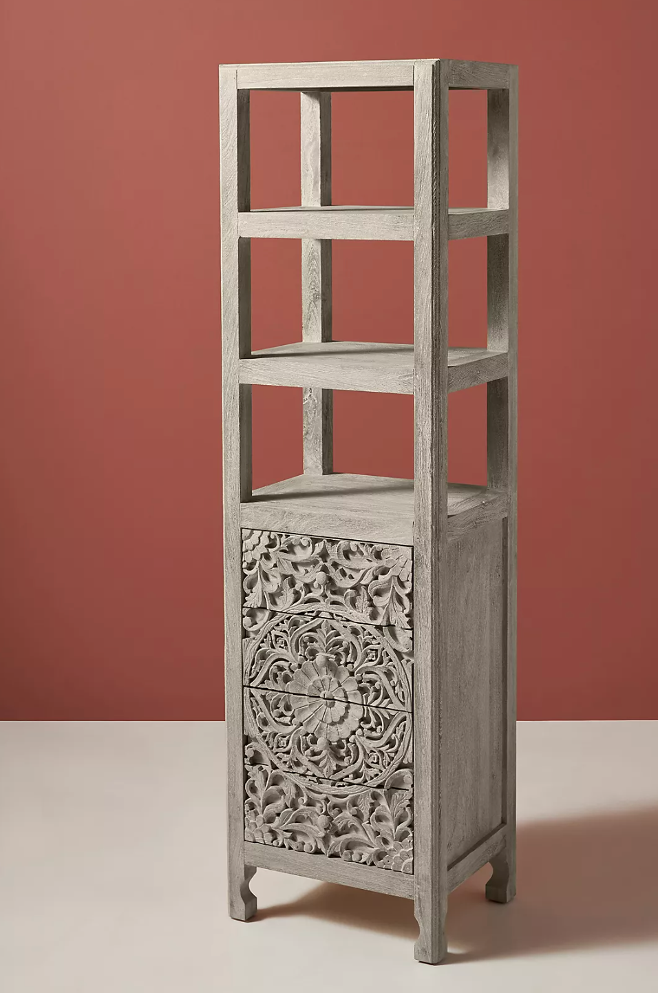 Brown narrow tall wooden accent cabinet with carved pattern on the drawers