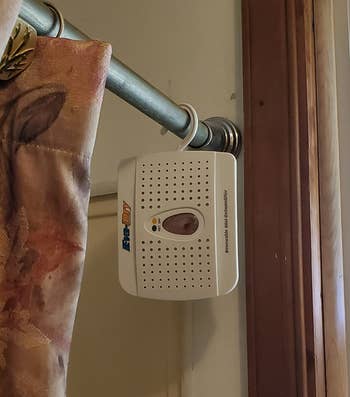 Dehumidifier hanging from a reviewer's curtain rod