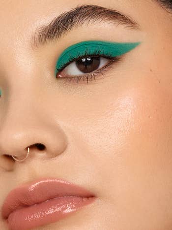 model wears green liquid eyeshadow