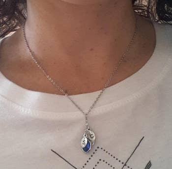 Reviewer wearing the silver initial necklace with birthstones