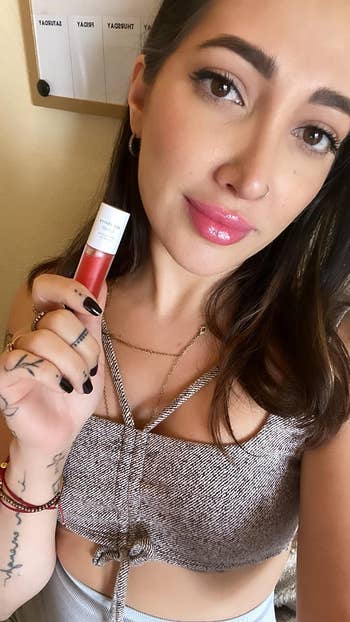 reviewer selfie wearing and holding the lip oil