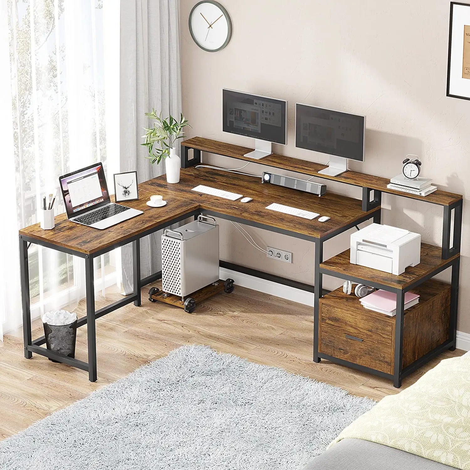 a large wooden desk with three computers and other devices set up on it