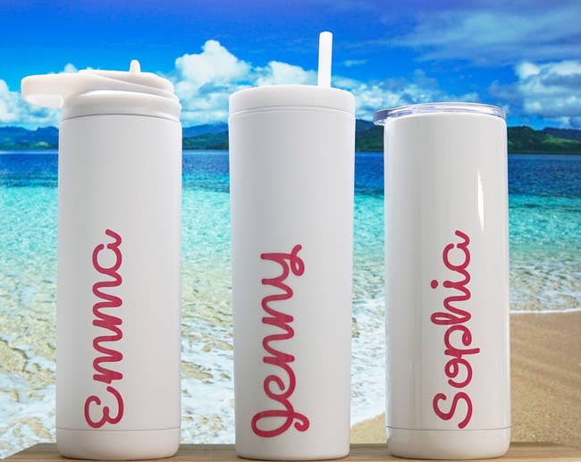 three water bottles with pink writing on them like the ones on love island